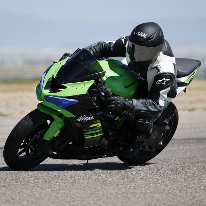 Ashish leaned into a corner on track aboard a green Kawasaki Ninja